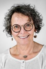 Frau Springsklee trägt kurze, dunkle, gelockte Haare und eine Brille. Sie lächelt freundlich.