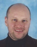 Roland Müller Herr Müller trägt kurzes, helles Haar und einen Bart. Er lächelt freundlich.