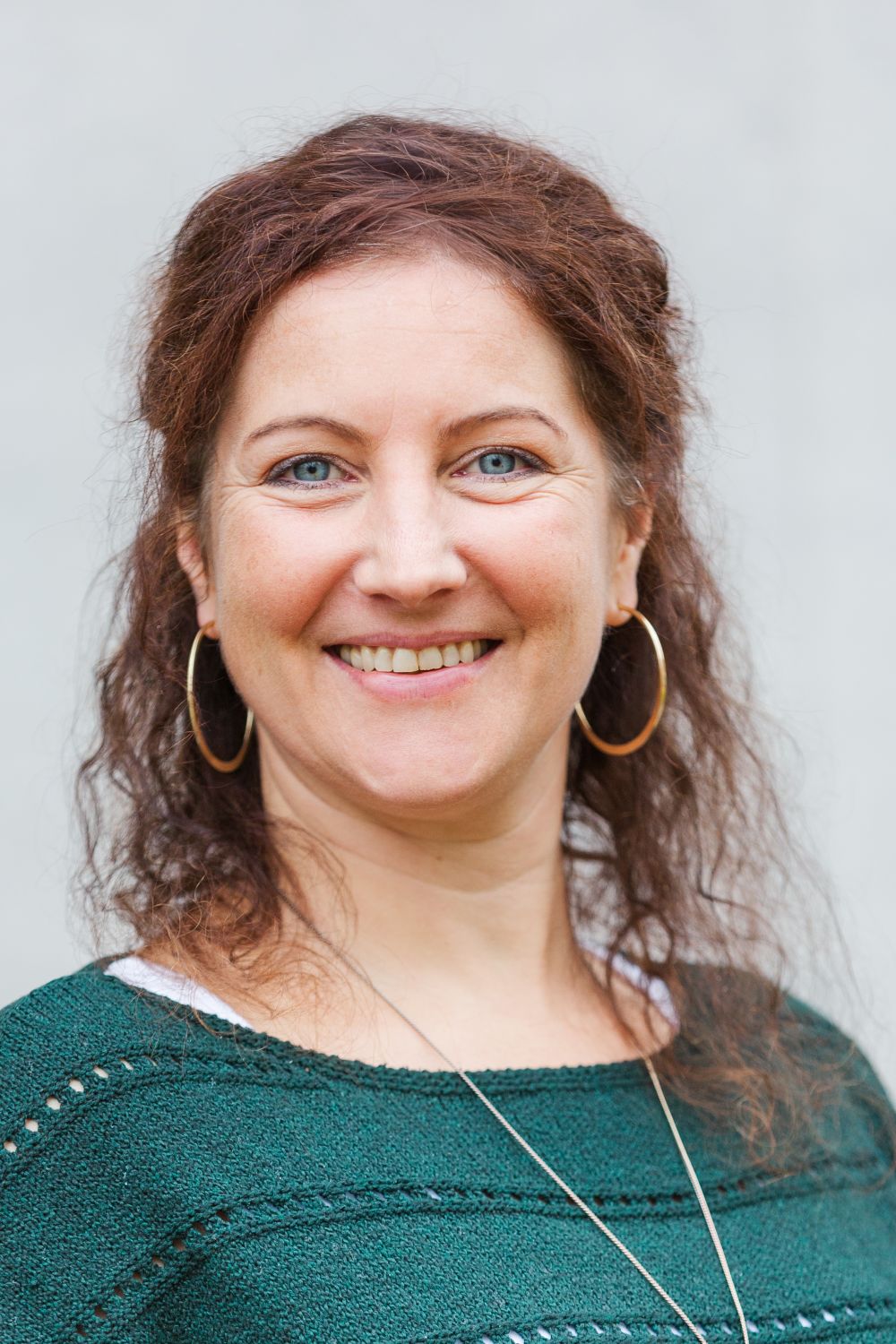 Frau Ketterer trägt braune, lange, gelockte Haare und lächelt freundlich.