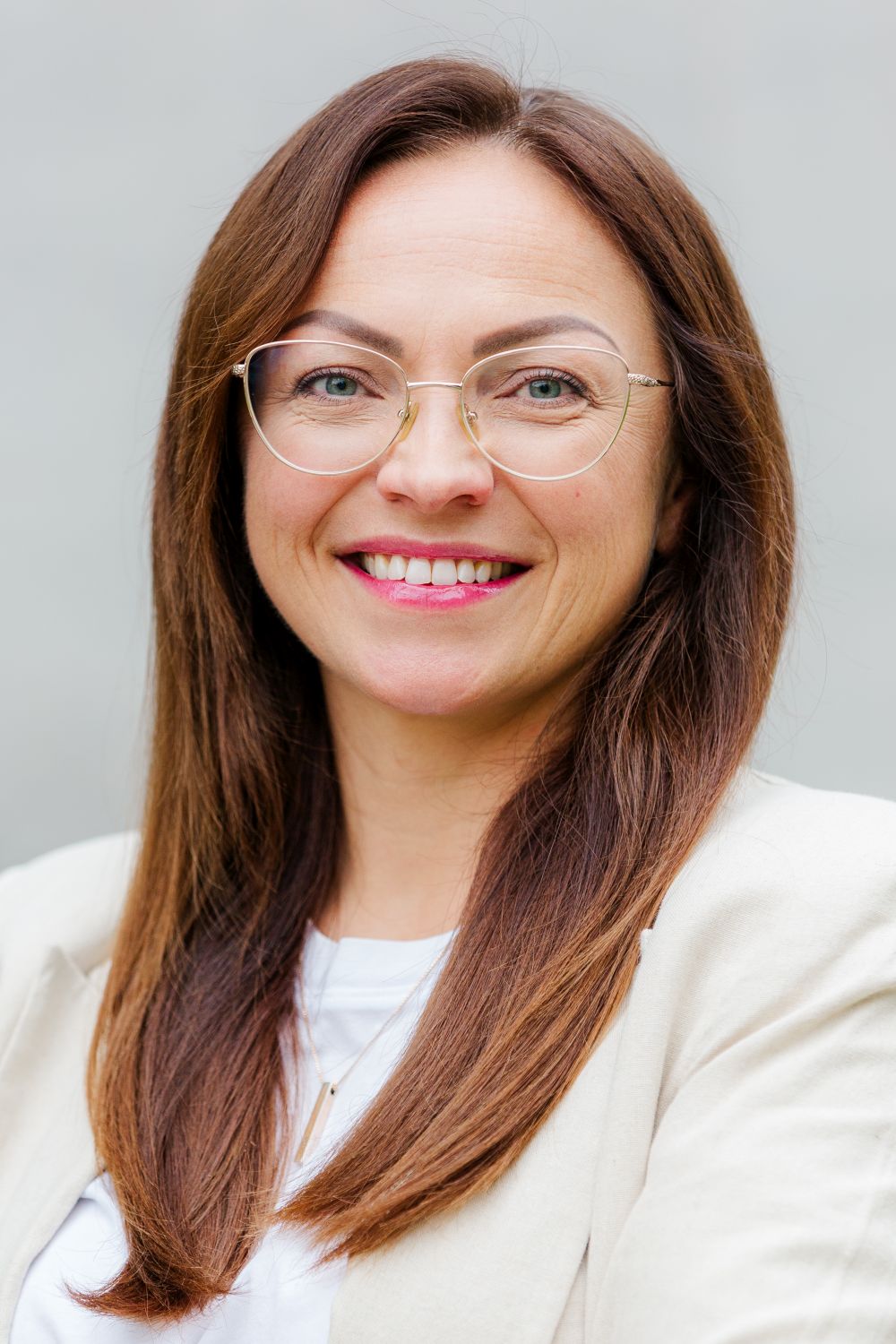 Frau Rollhäuser trägt braune, lange Haare und eine Brille. Sie lächelt freundlich.