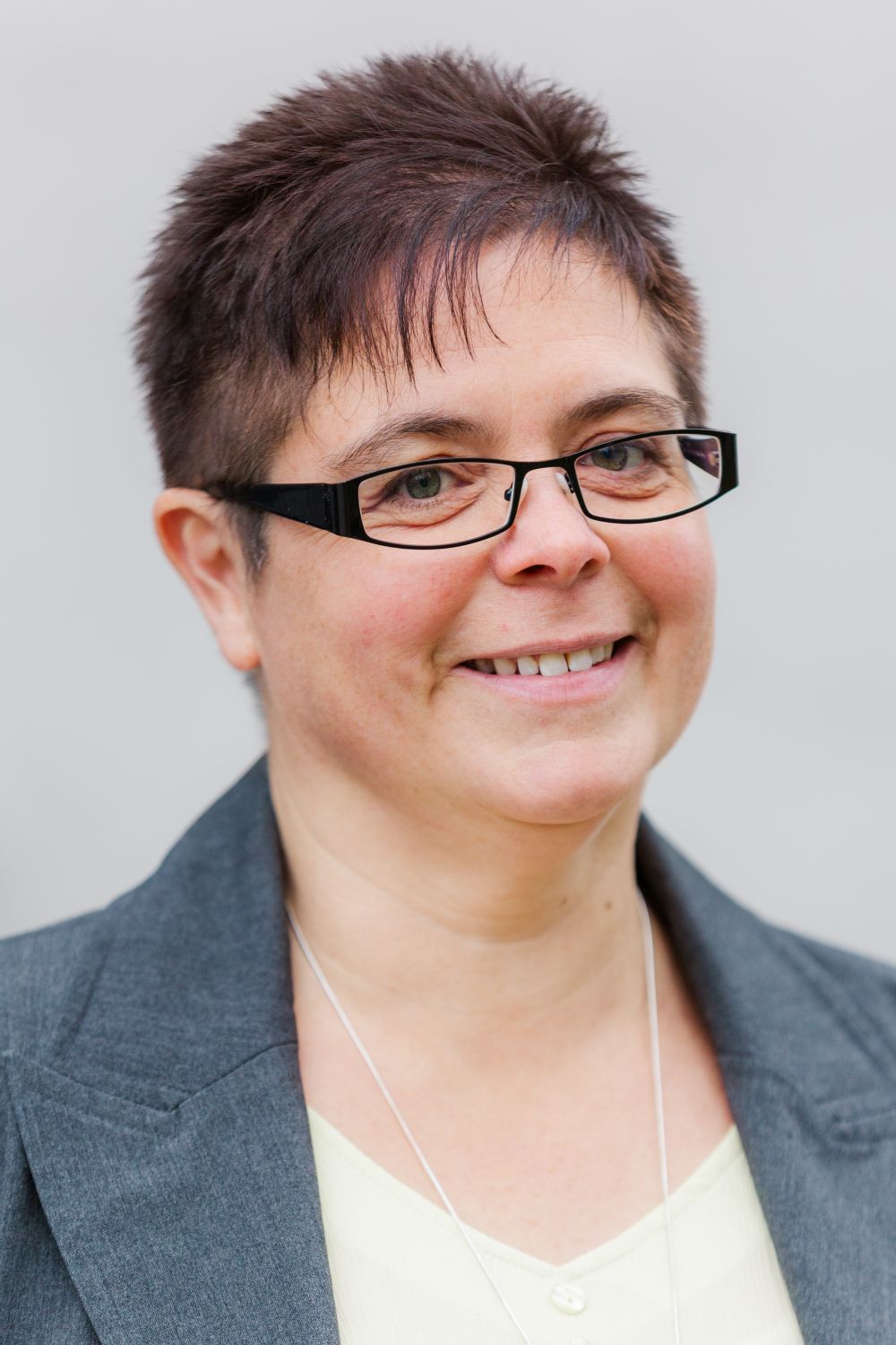 Frau Machado Friedrich trägt kurze, braune Haare und eine Brille. Sie lächelt freundlich.