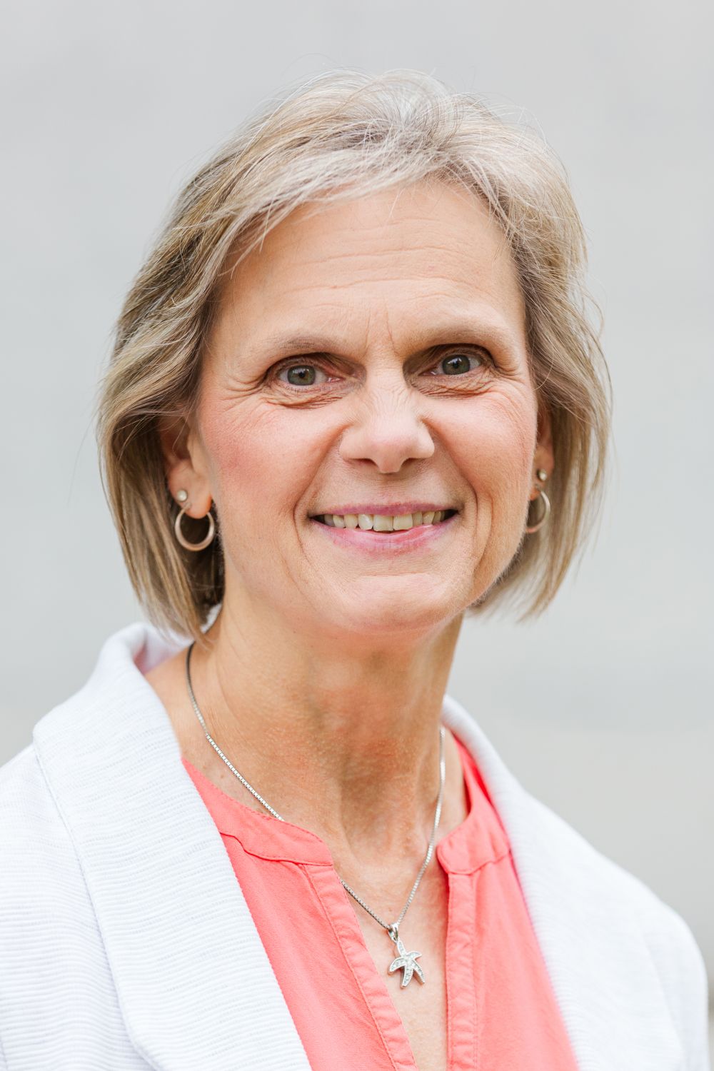 Frau Kammerer trägt kurze, blonde Haare und lächelt freundlich.