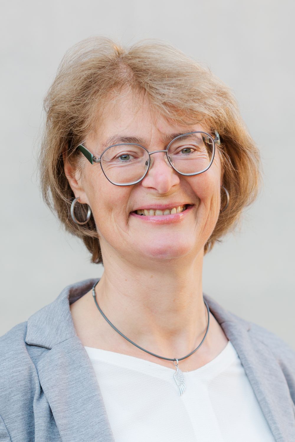 Frau Vosseler trägt blondes, halblanges Haar und eine Brille. Sie lächelt freundlich.